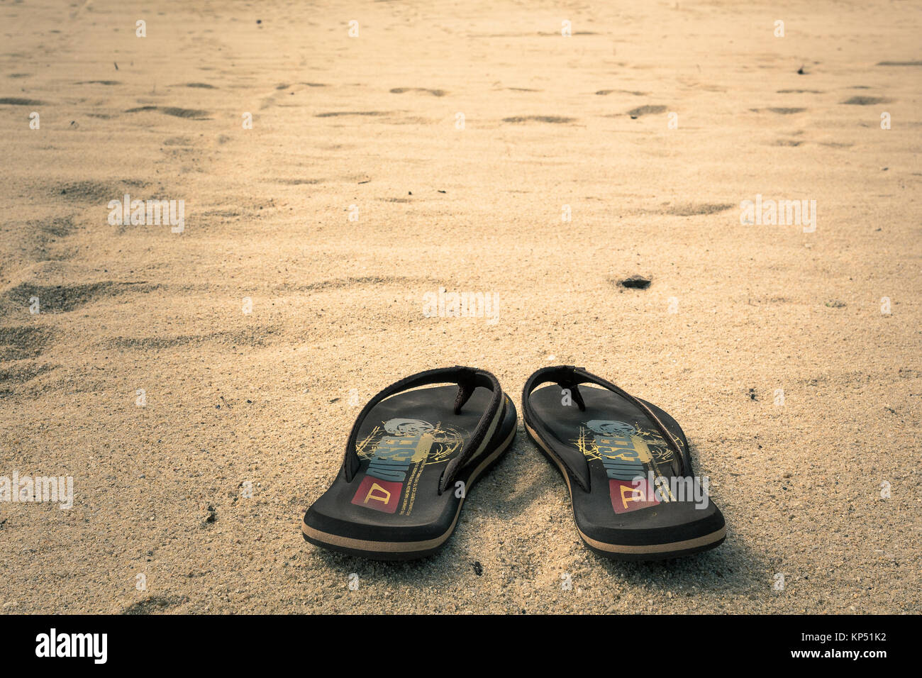 Just a pair of flipflops on a sandy beach in Lamai beach on Koh Samui in wonderful Thailand. Stock Photo
