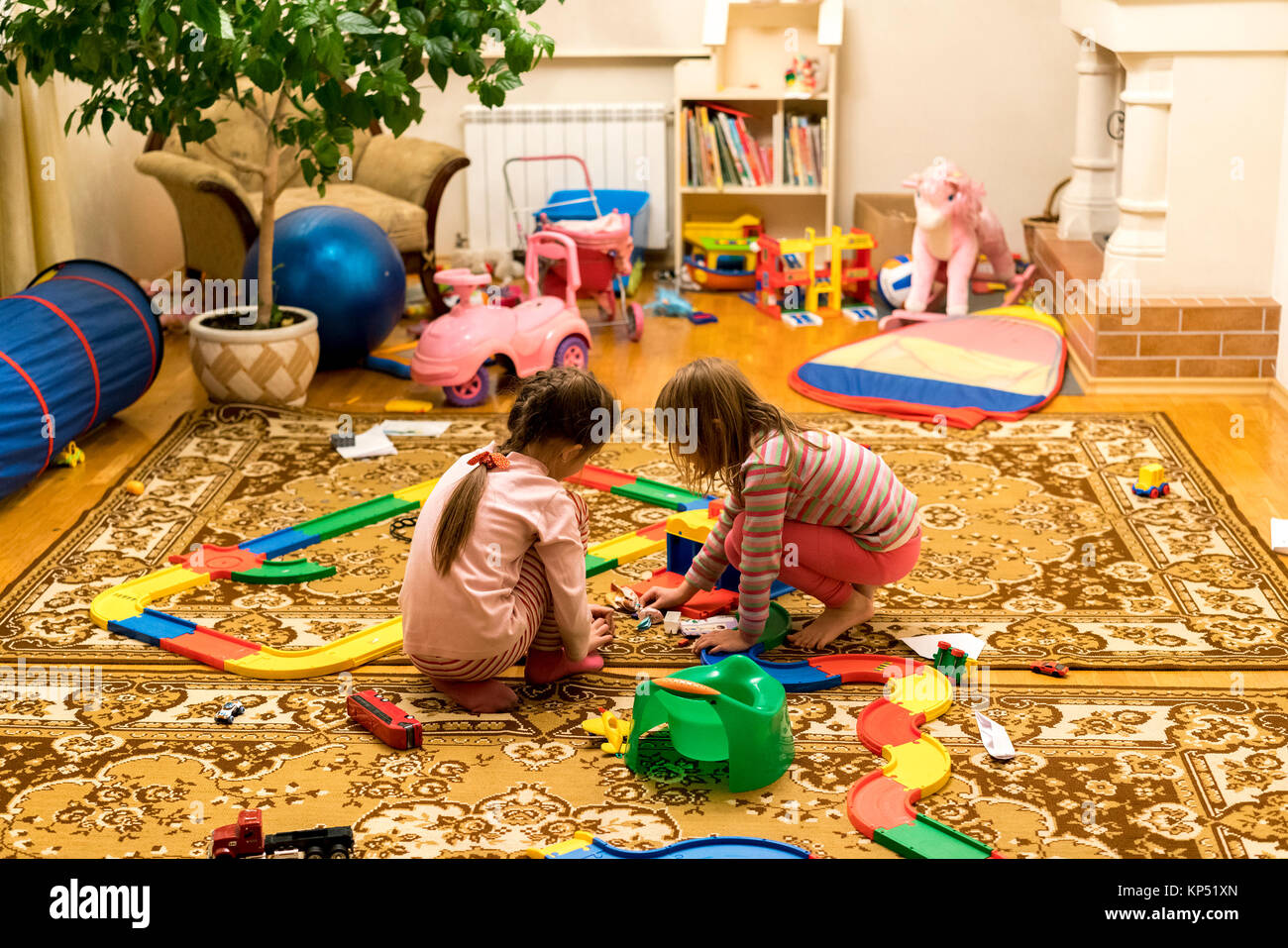 Two little girls play with toys in the room Stock Photo - Alamy