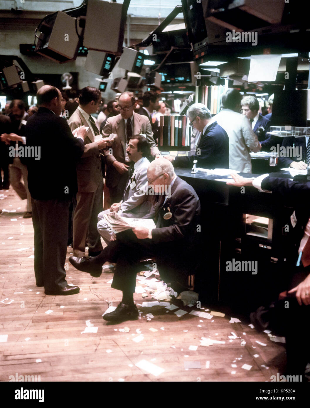 May 1982,New York,Stock Exchange interior,trading floor,broker reading financial paper,traders chatting,Manhattan,New york City,NY,NYC,USA, Stock Photo