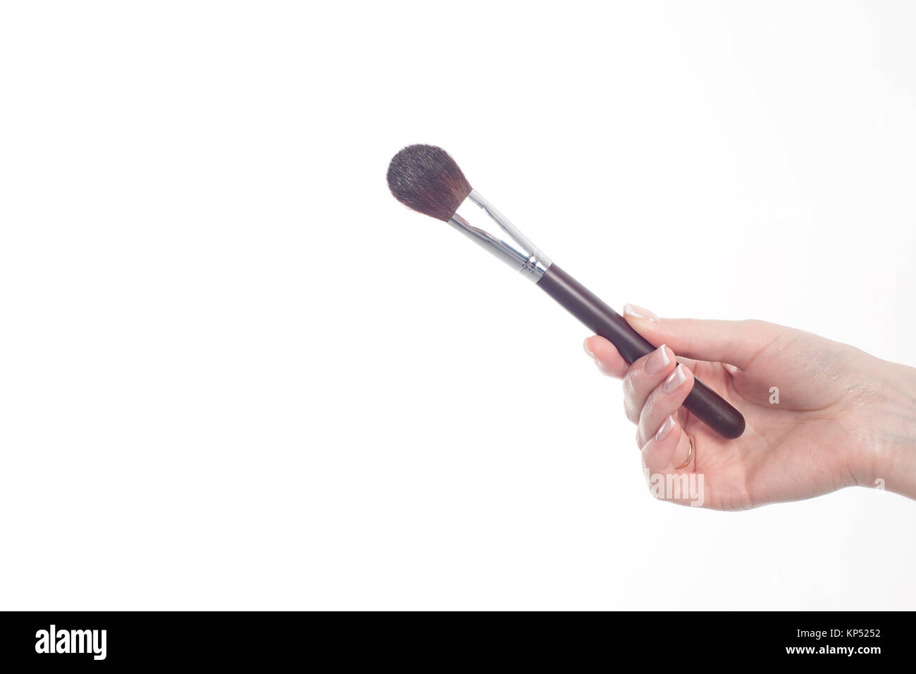 Female hand holding professional make-up brushe isolated on white background Stock Photo