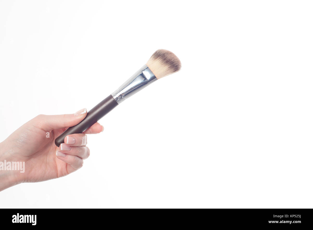 Female hand holding professional make-up brushe isolated on white background Stock Photo