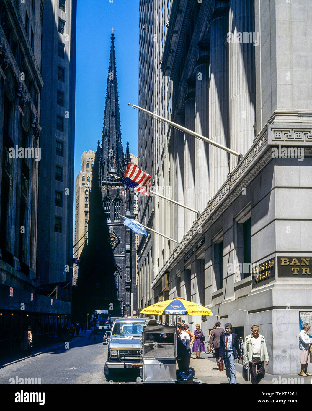 May 1982,New York,Wall street,mobile food cart vendor,hot dog dogs, Trinity church,financial district,lower Manhattan,New york City,NY,NYC,USA, Stock Photo