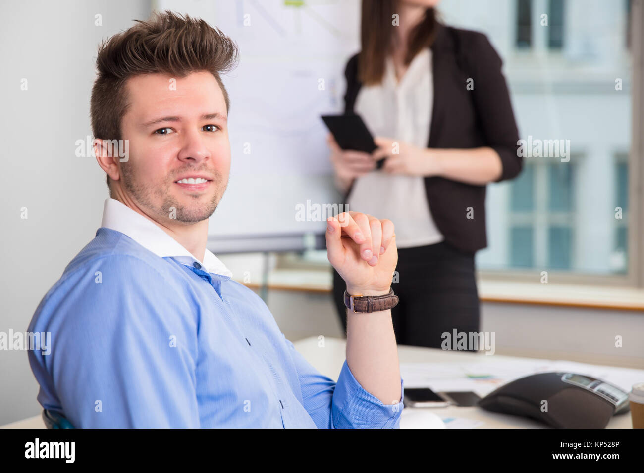 Confident Businessman Smiling While Colleague Standing At Office Stock Photo