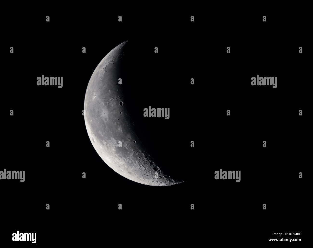 Waning Crescent moon at 30% in the night sky. Stock Photo