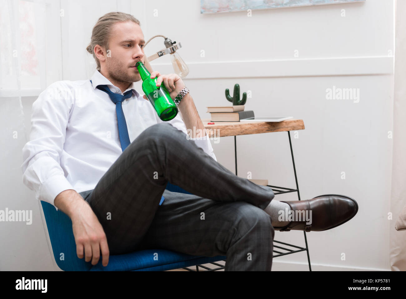 Handsome man sitting in a chair and drinking beer Stock Photo Alamy