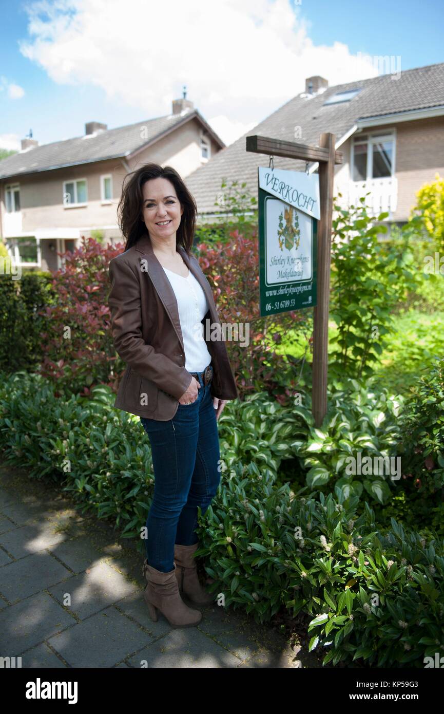 Tilburg, Netherlands. Portrait of a female real estate agent, in front