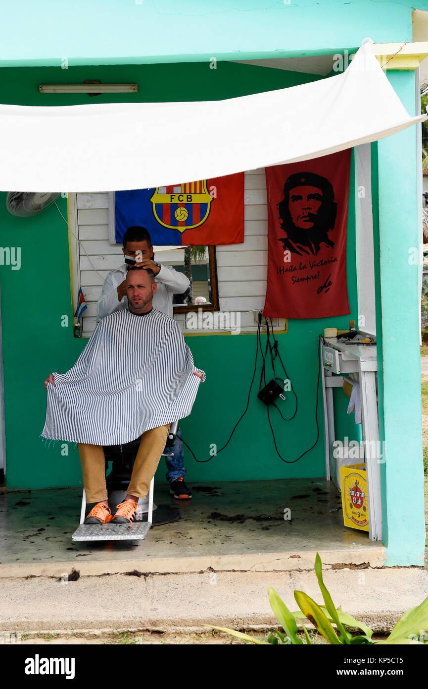 A Cuban hairdresser cuts a man's hair in barber shop, Vinales, Cuba. Stock Photo