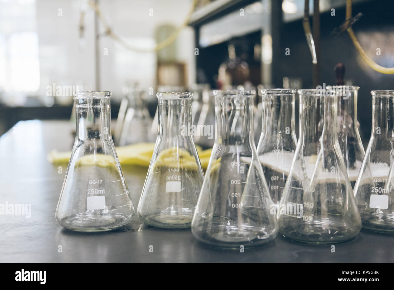 detail shot of beakers and equipment on table in factory laboratory ...