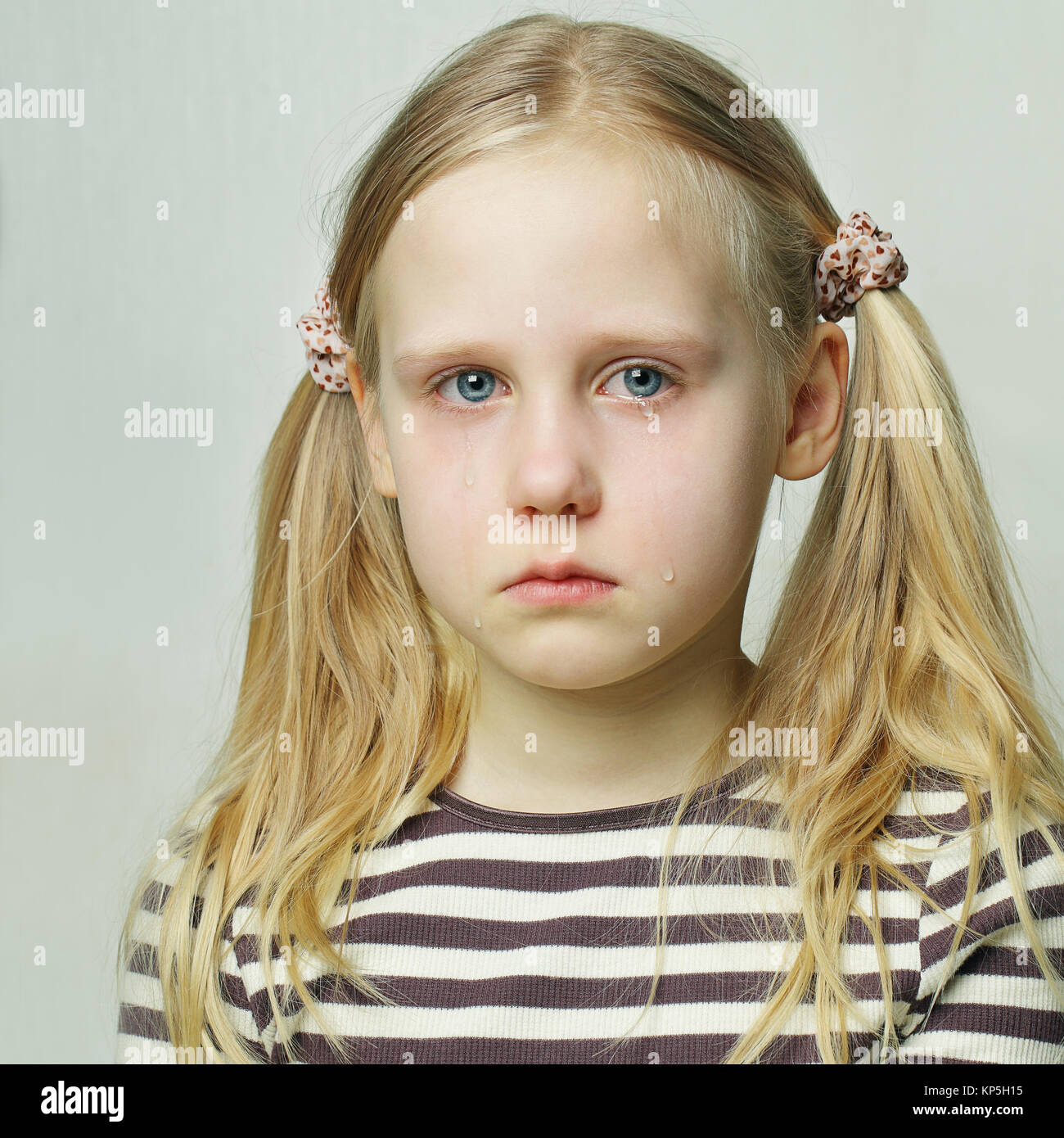 Little girl with sad expression and tears Stock Photo