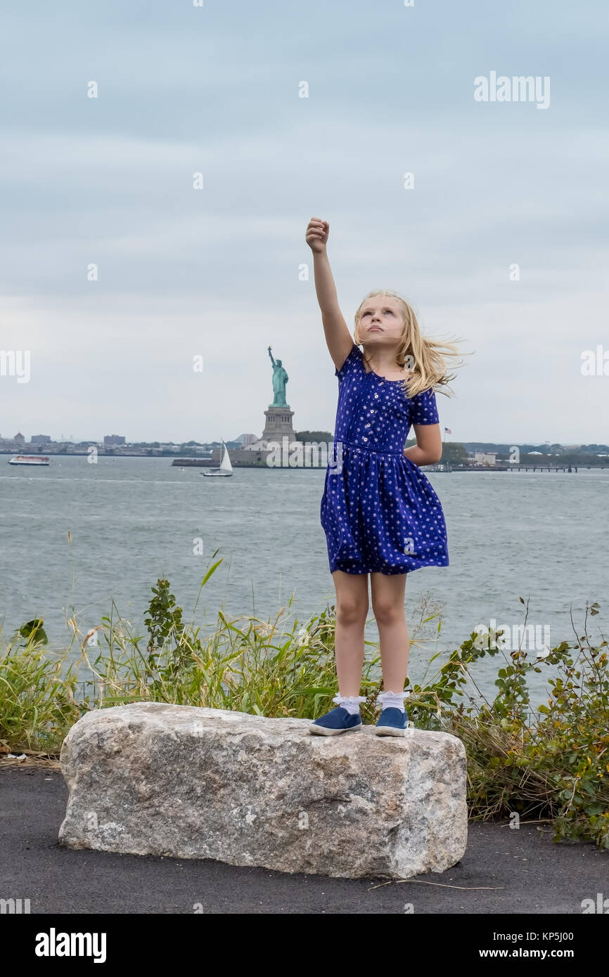 a girl standing tall and strong like statue of liberty to represent women's rights Stock Photo