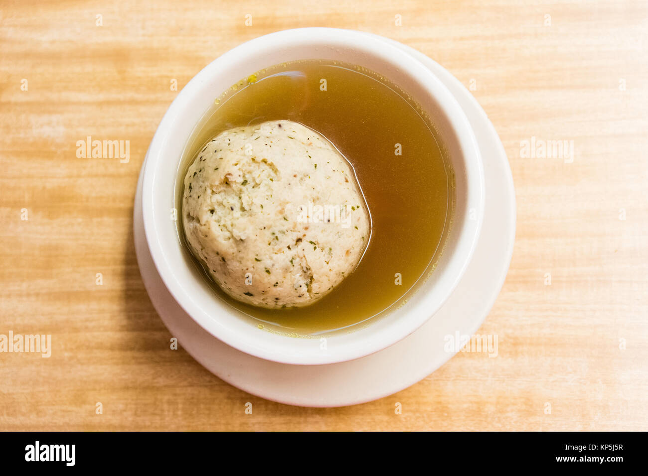 close up of large matzo ball in bowl of soup Stock Photo
