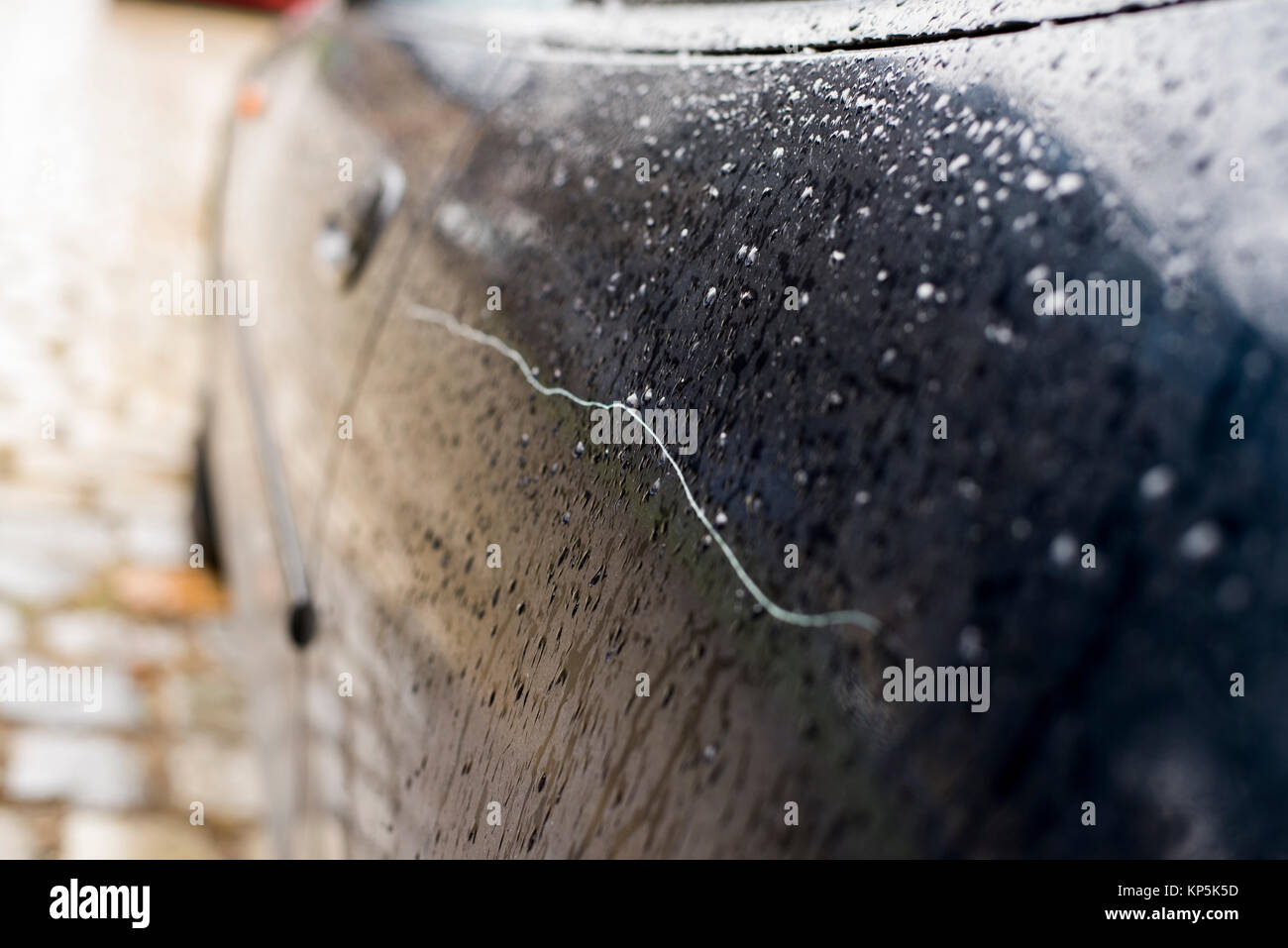 Scratched car paint with door handle and tire out of focus Stock Photo