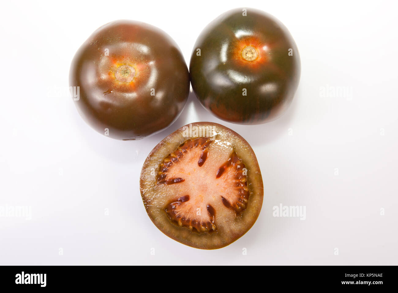 Whole and sliced kumato tomatoes Stock Photo Alamy