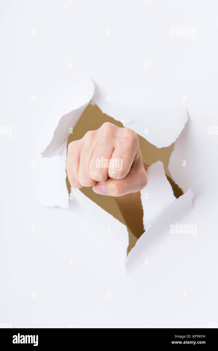 Fist punching through paper Stock Photo Alamy
