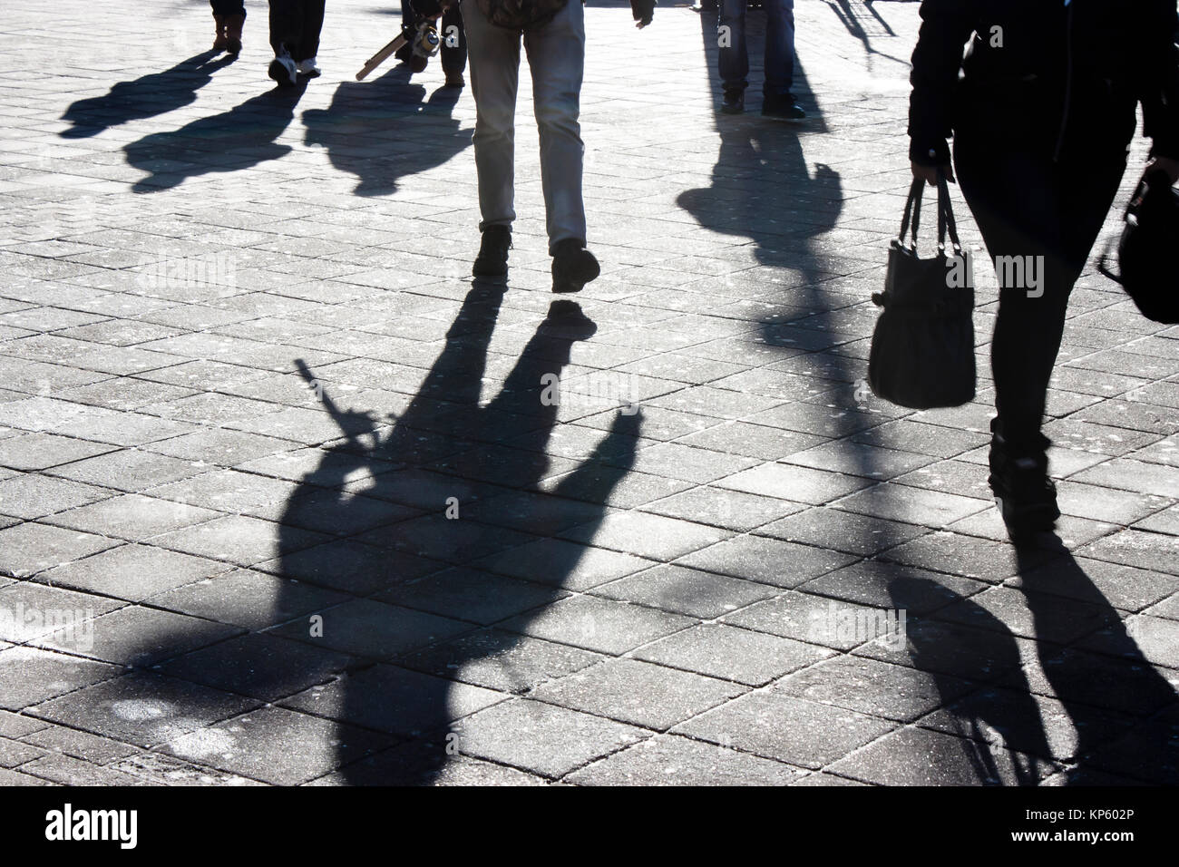 Shadows and silhouettes of people walking the city street in winter in ...