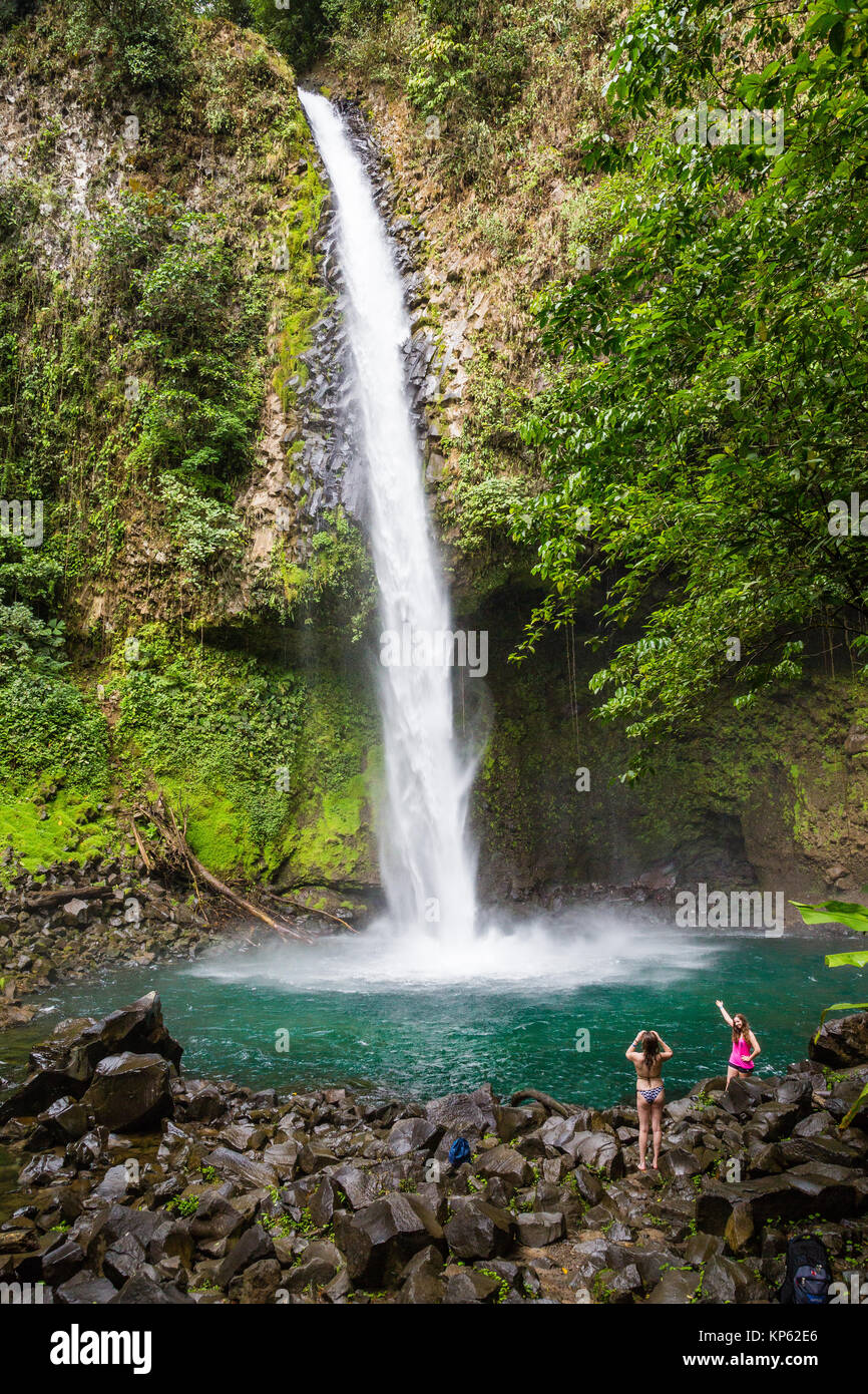 Bathers in the plunge pool of La Fortuna Waterfall or Catarata Fortuna near the Arenal volcano in Northern Costa Rica Stock Photo