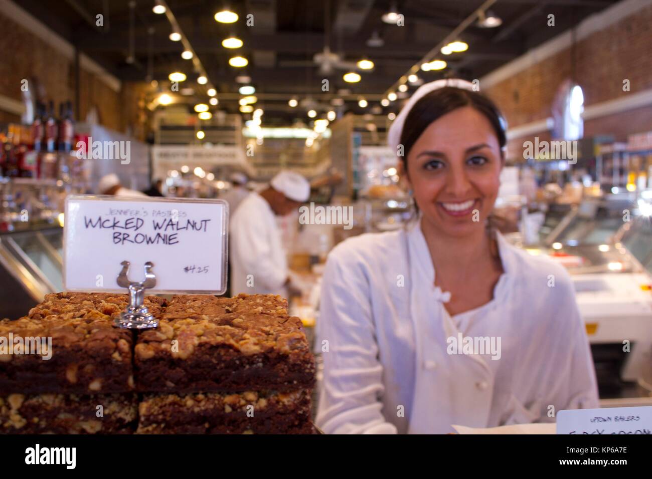 Young lady selling ""Wicked Walnut Brownie"" at the bakery section of