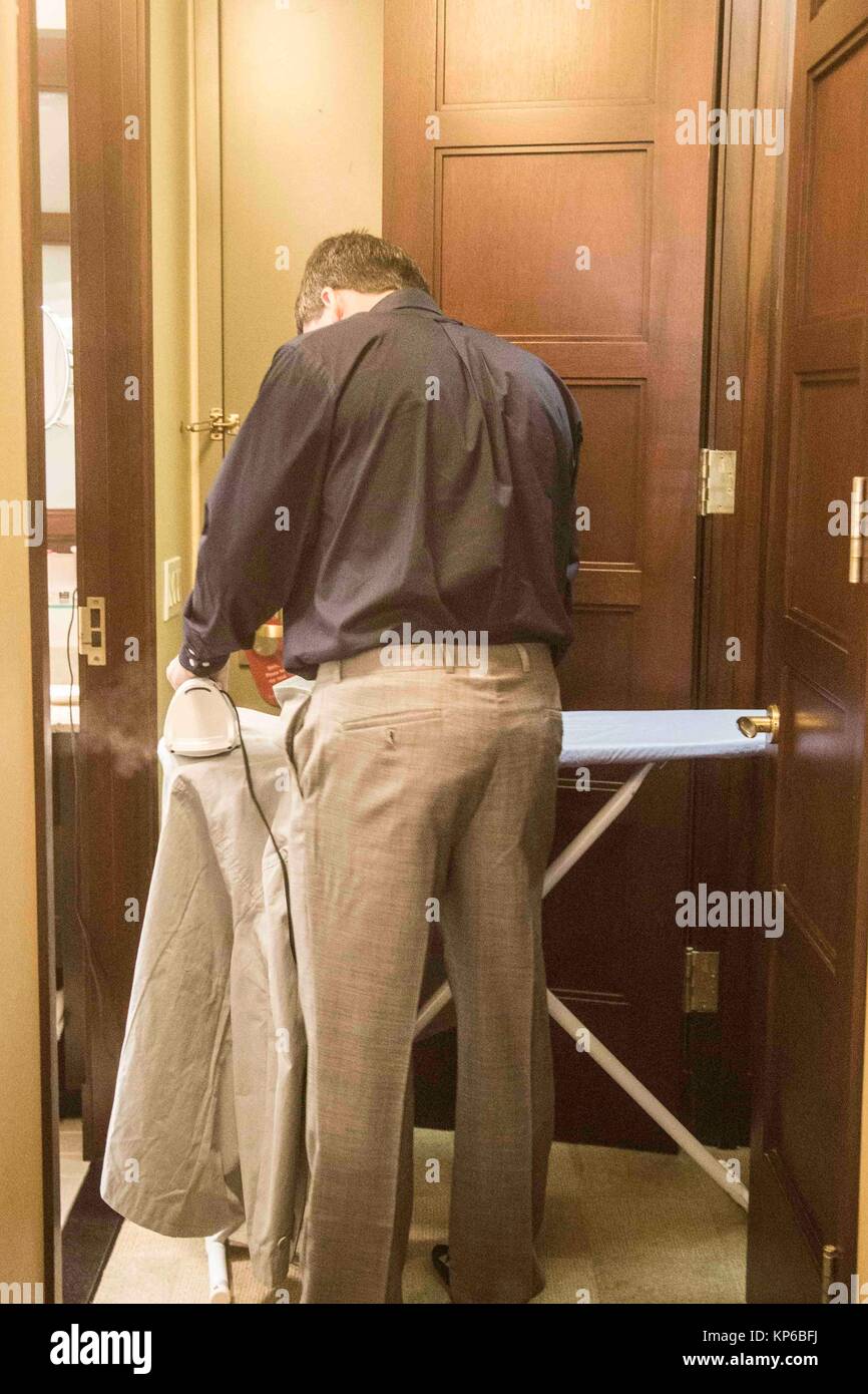 Caucasian man in his 30´s, 40´s, 50 ´s ironing his jacket suit on an