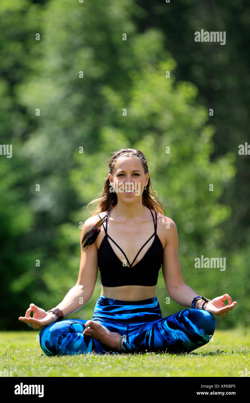 Woman doing yoga and meditation outside. Lotus position. Les Contamines. France. Stock Photo