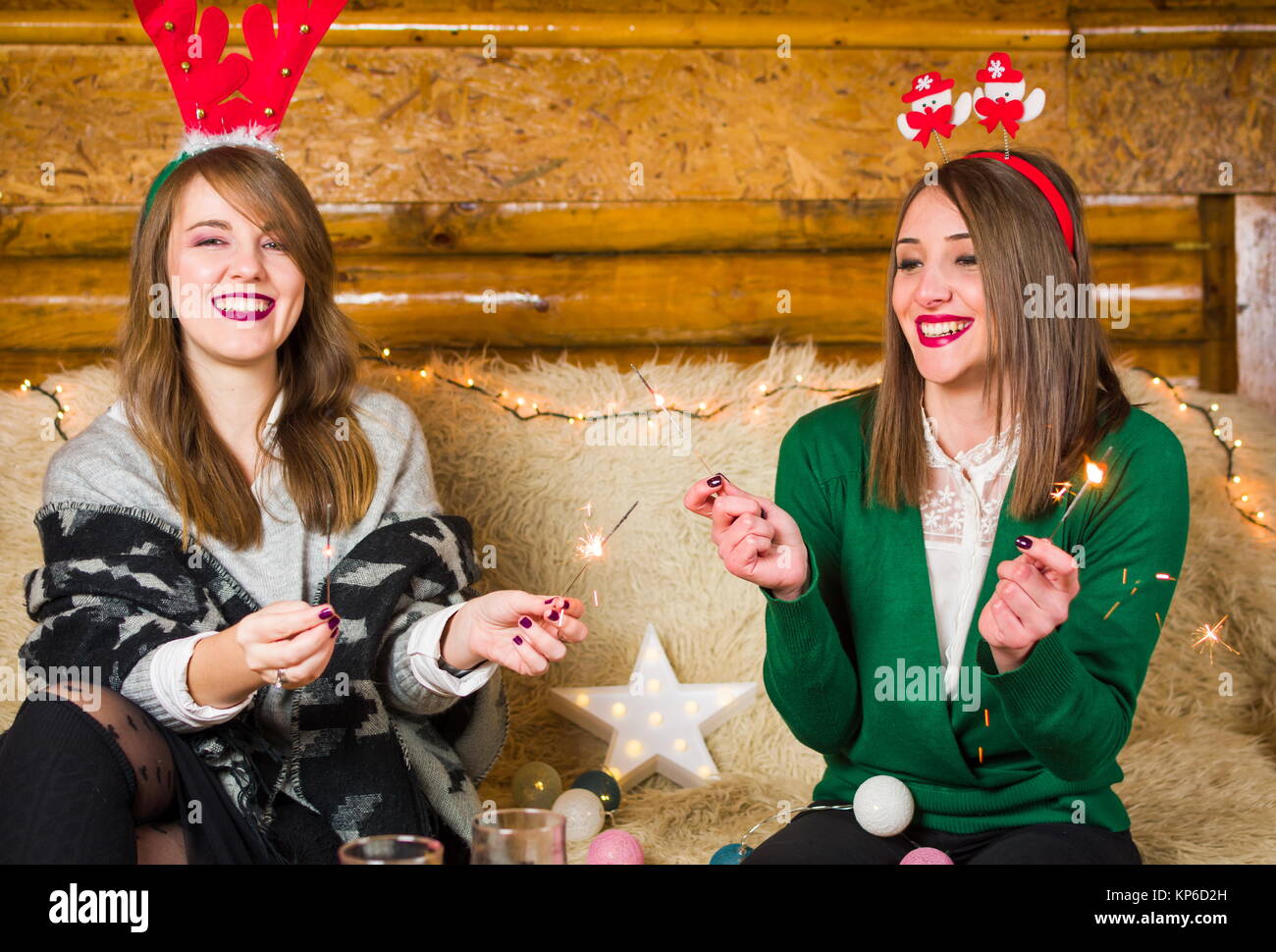 Friends having fun with fire sparkles on home Christmas party Stock Photo