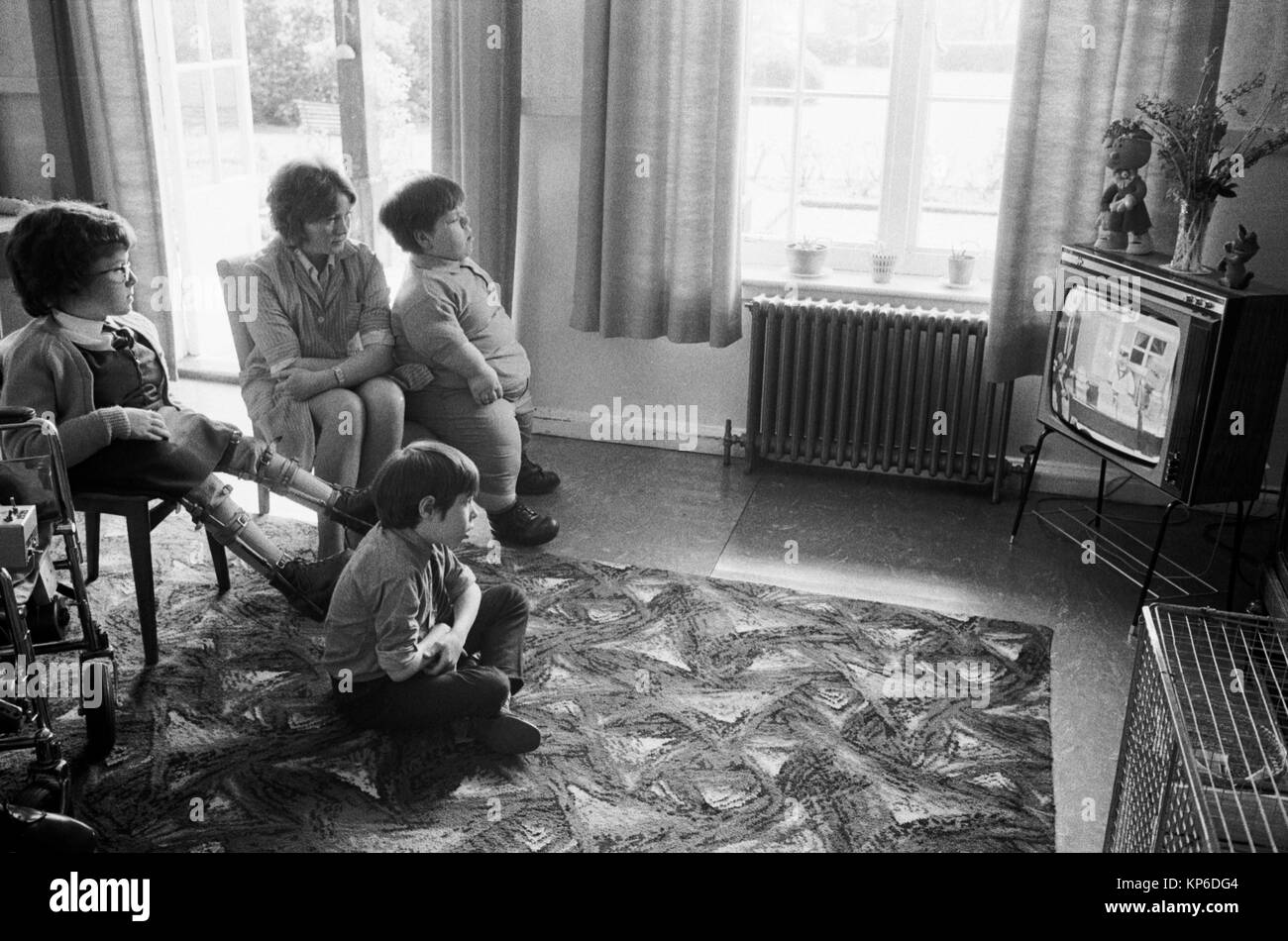 Children and carer watching TV at Elmfield School a National Children's Home a specialist school for children with physical disabilities  1970s Uk. Harpenden, Hertfordshire, England 1975 HOMER SYKES Stock Photo