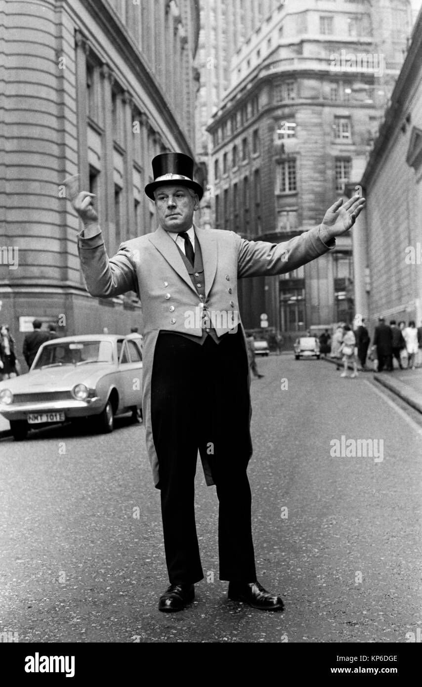 Bank of England doorman  in uniform directing a car into the private parking reception of the banks building in  Threadneedle Street  City of London 1970s England 70s Uk HOMER SYKES Stock Photo