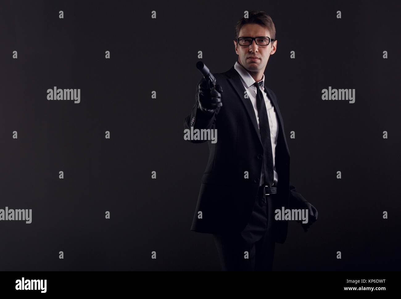 Picture of man in glasses and leather gloves with gun Stock Photo