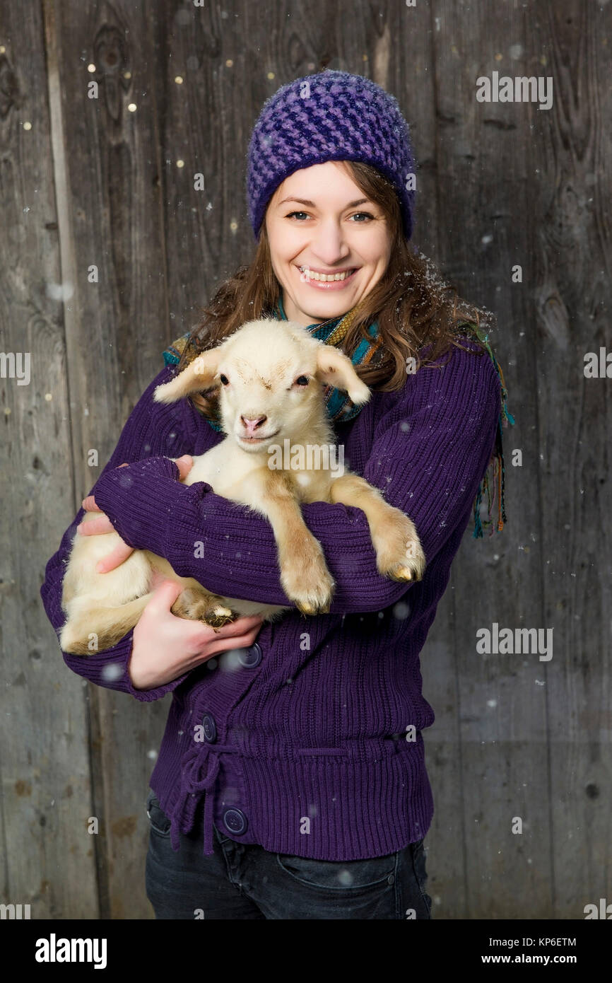 Frau mit Laemmchen bei Schneefall - woman with little lamb Stock Photo