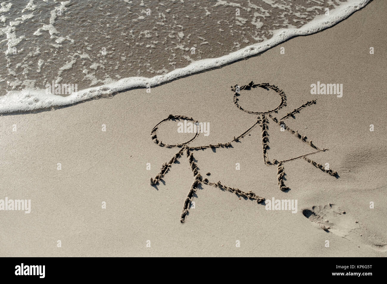 Paar im Sandstrand - couple at the beach, symbolic for Stock Photo