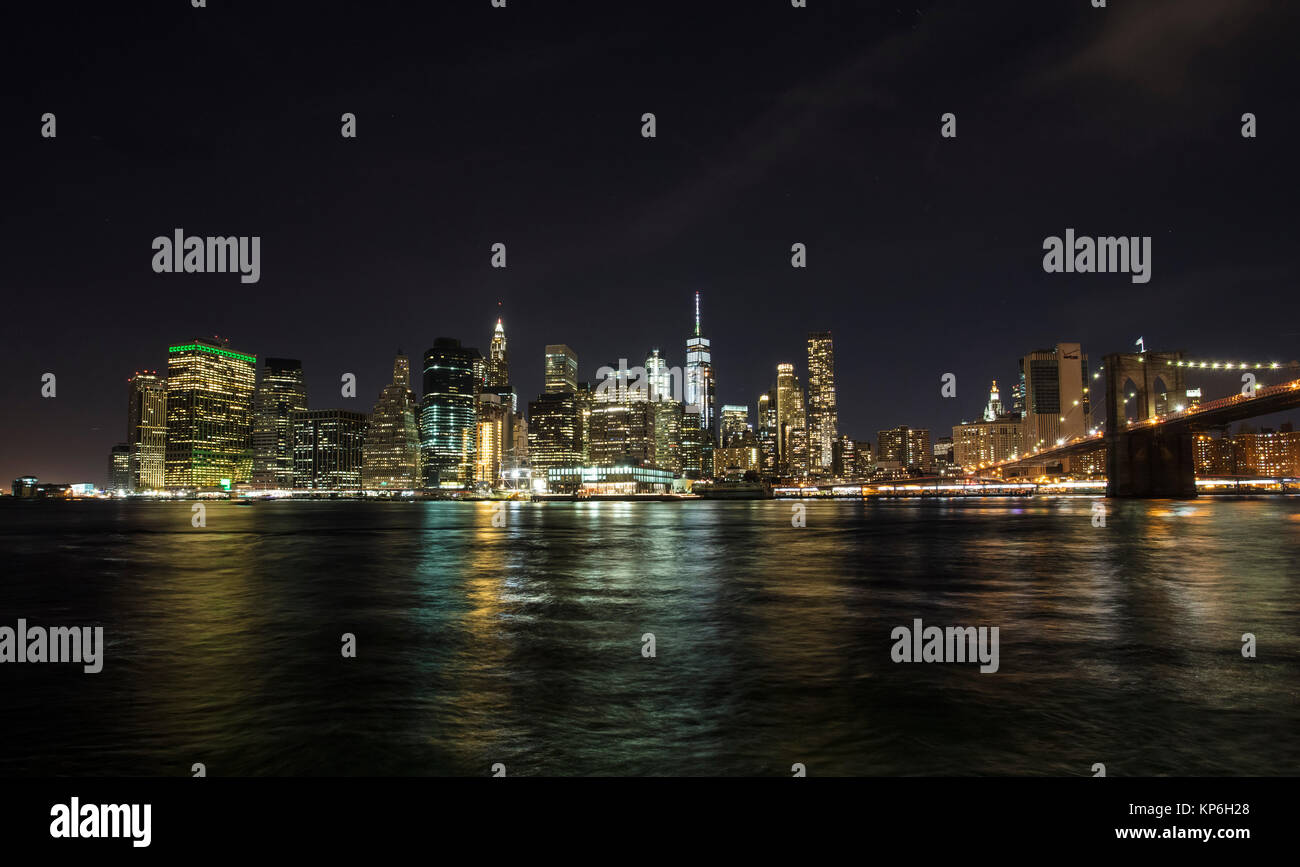 New York, Manhattan Skyline and Brooklyn Bridge at Night reflected in ...