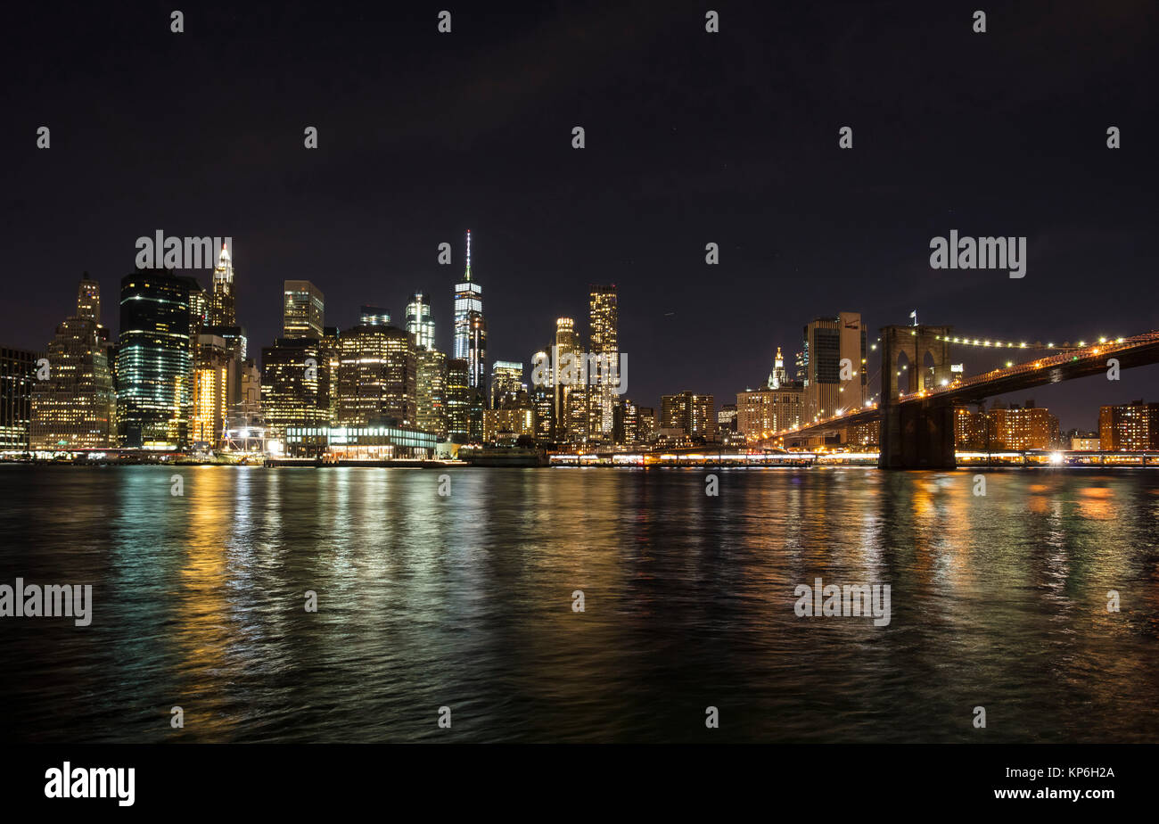 New York, Manhattan Skyline and Brooklyn Bridge at Night reflected in ...