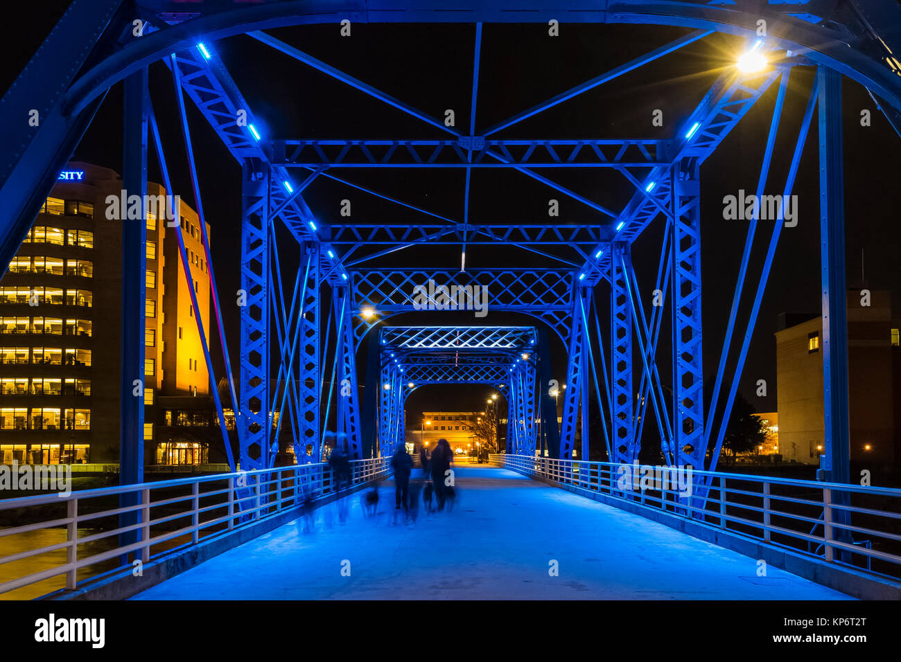 Group walking dogs at night on the Blue Bridge over the Grand River in Grand Rapids, Michigan, USA Stock Photo