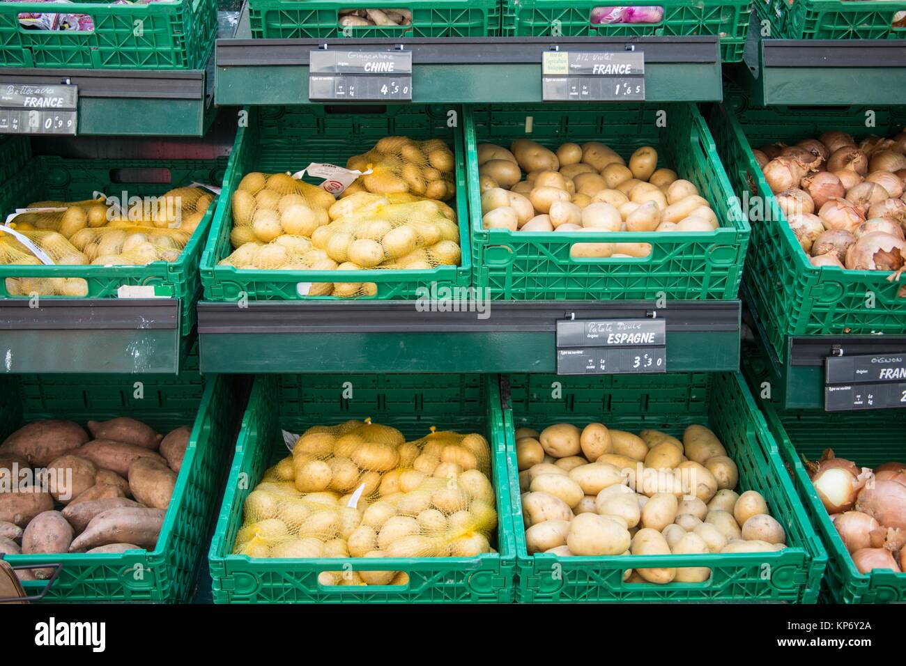 So many different kind of potatoes and onions for sale in bulk at an