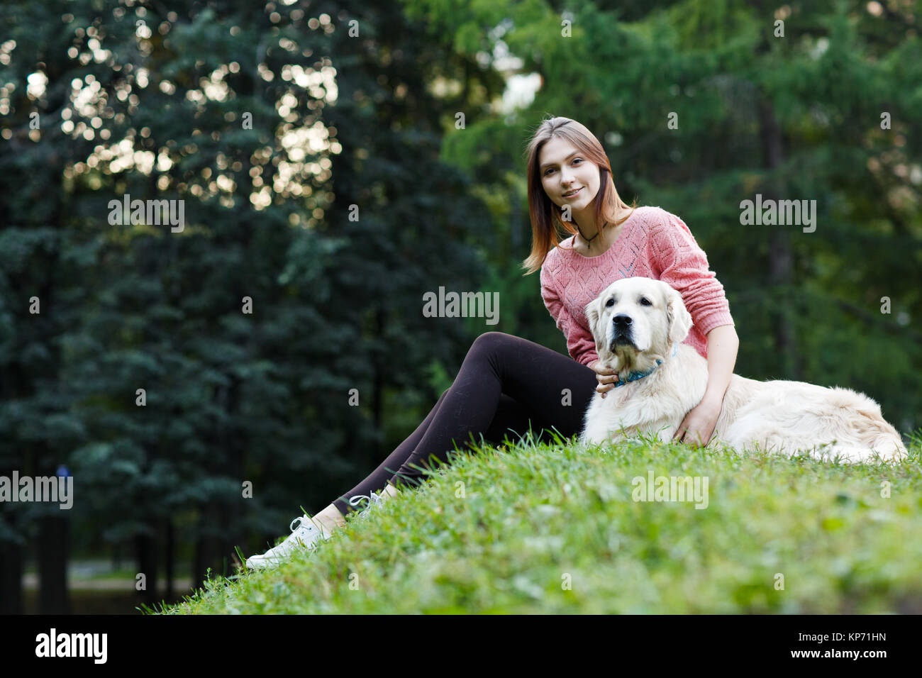 Image from below of girl sitting with dog on green lawn Stock Photo - Alamy