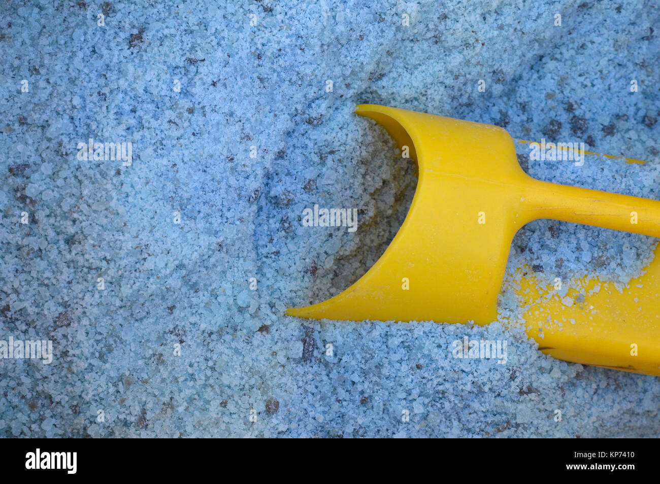 Blue road salt with a yellow scoop Stock Photo