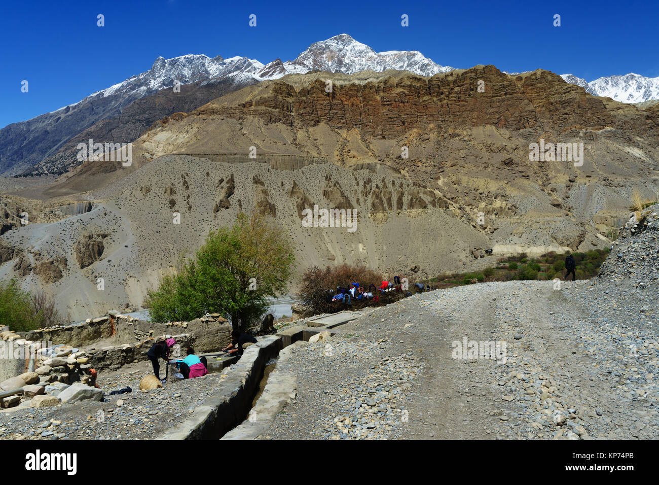Nepalese women washing clothes by the side of the gravel road between Tangbe and Chuksang, Upper Mustang region, Nepal Stock Photo