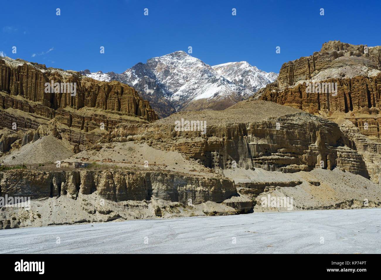 Spectacular cliffs and snowy peak seen from Chuksang, Upper Mustang region, Nepal. Stock Photo