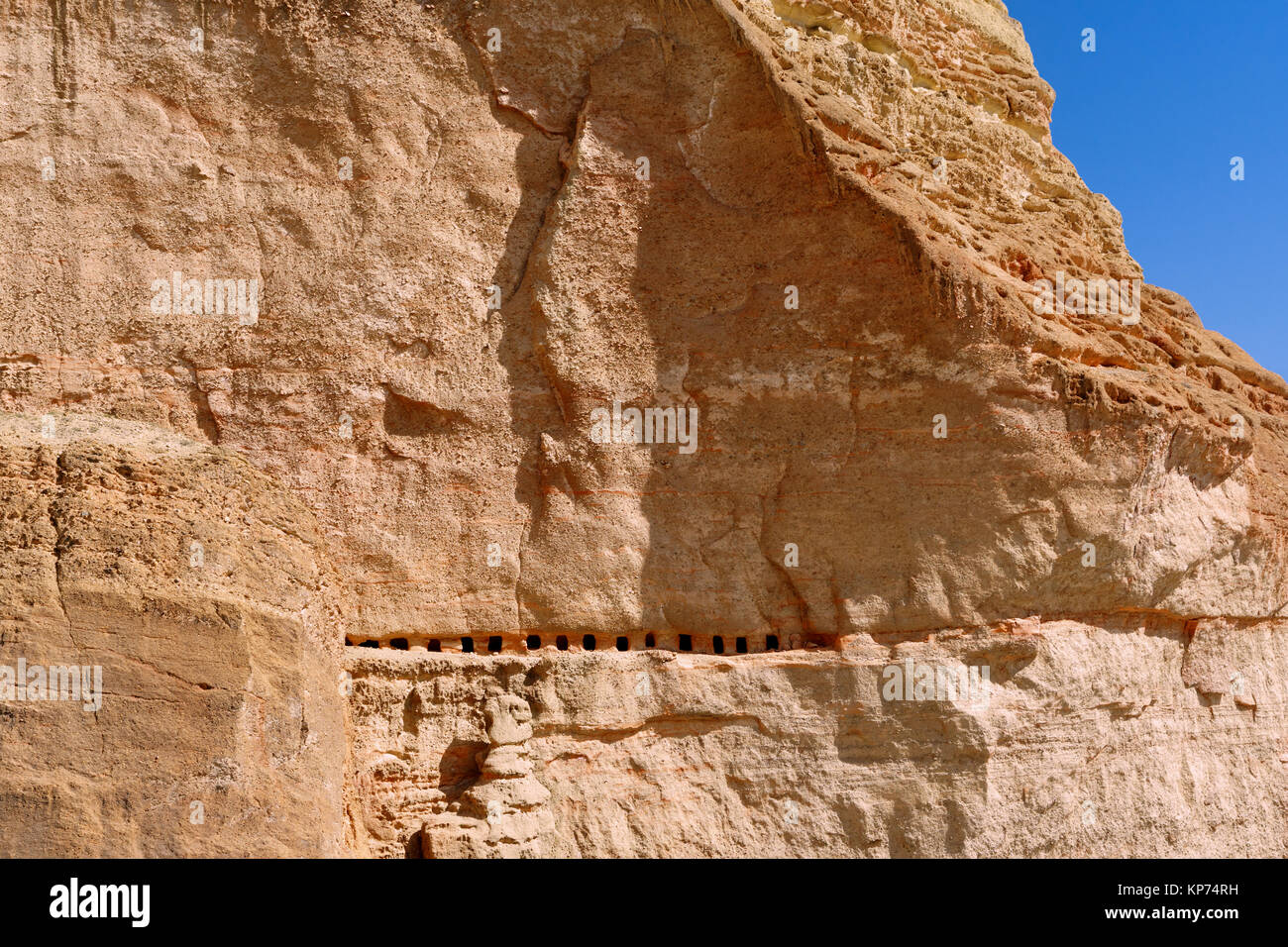 Row of cave dwellings carved in a cliff near Chele, Upper Mustang region, Nepal. Stock Photo