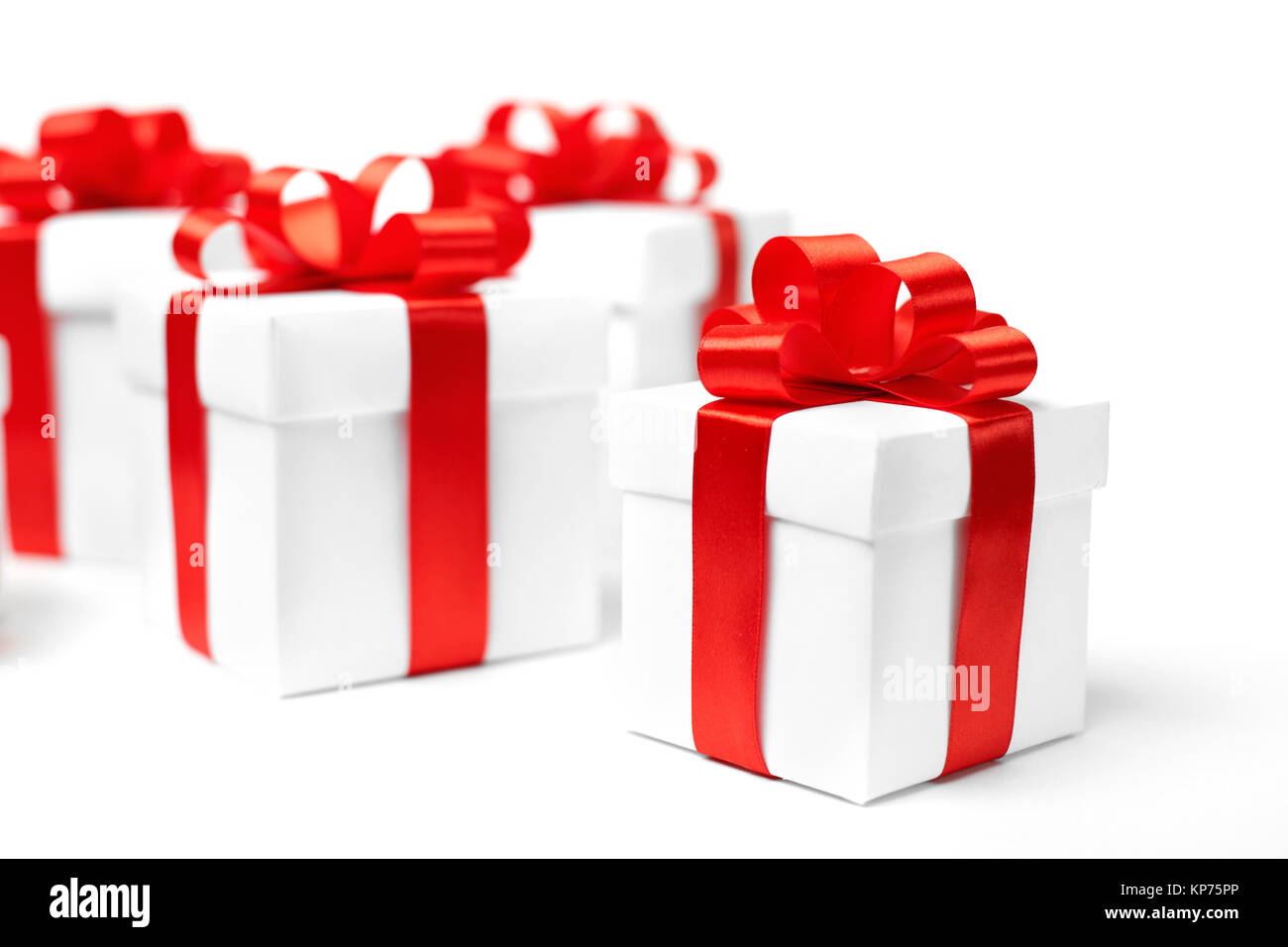 White gift box with red ribbon bow and christmas balls around, isolated ...