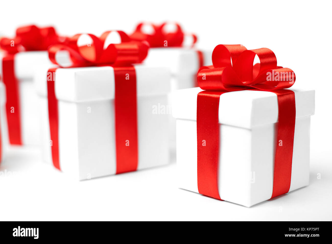White gift box with red ribbon bow and christmas balls around, isolated ...