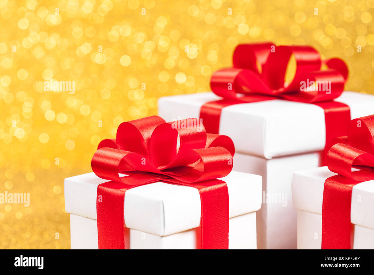 White gift box with red ribbon bow on gold glitter background Stock ...
