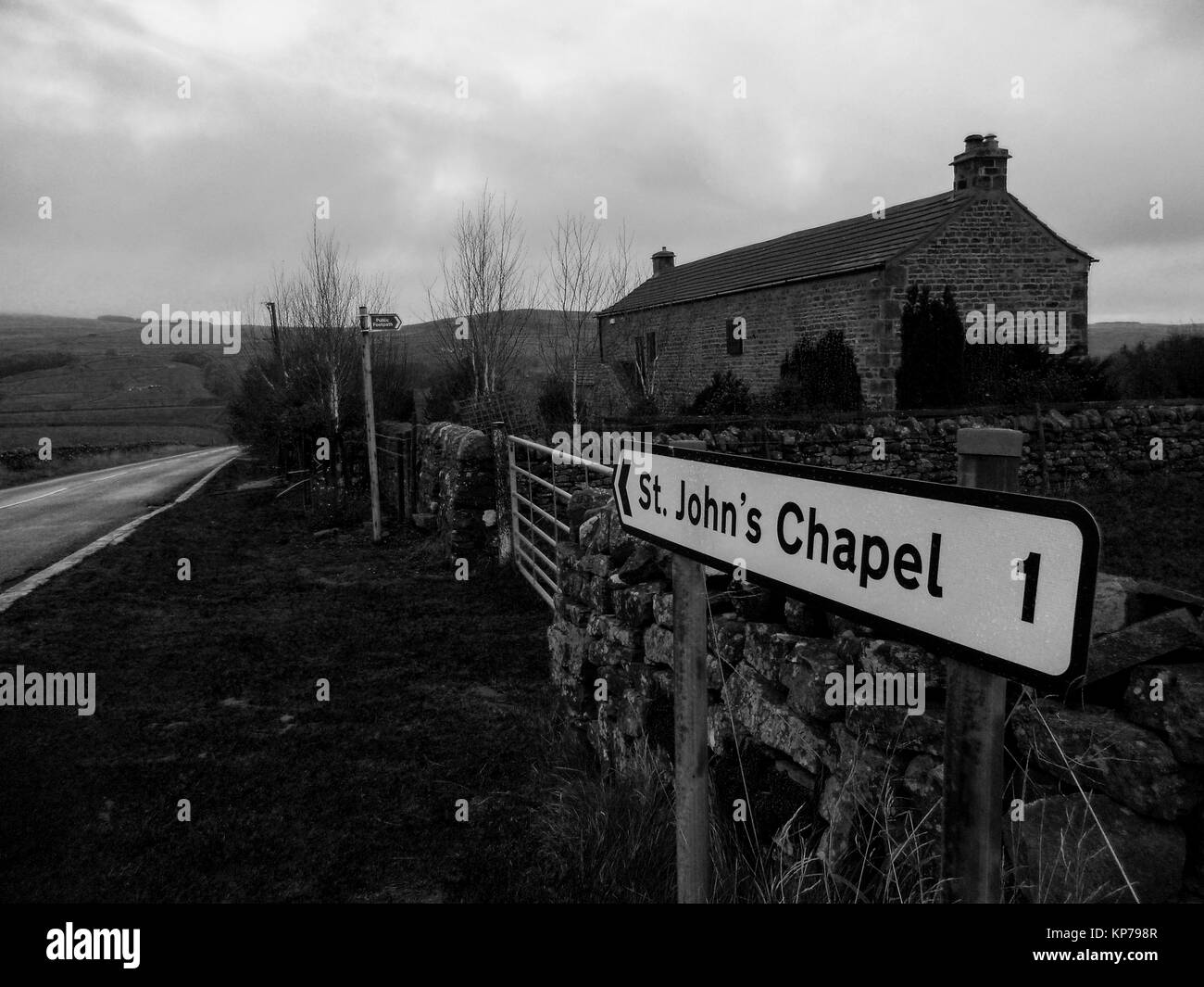 A metal sign telling the distance to the village of St John's Chapel, in Upper Weardale in County Durham. Stock Photo