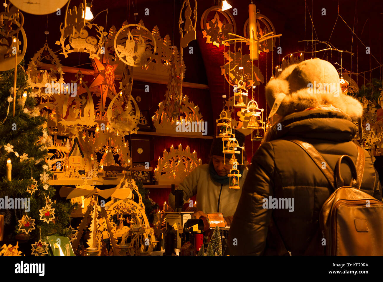 Christmas market in Basel, Switzerland. 9th of December 2017. A woman is buying traditional wooden christmas decorations made in Germany at one of the Stock Photo