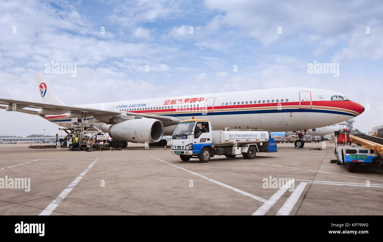 BEIJING-MAY 6, 2014. Airplane parked at Beijing Capital International Airport, ground personnel with equipment busy with supply and maintenance. Stock Photo
