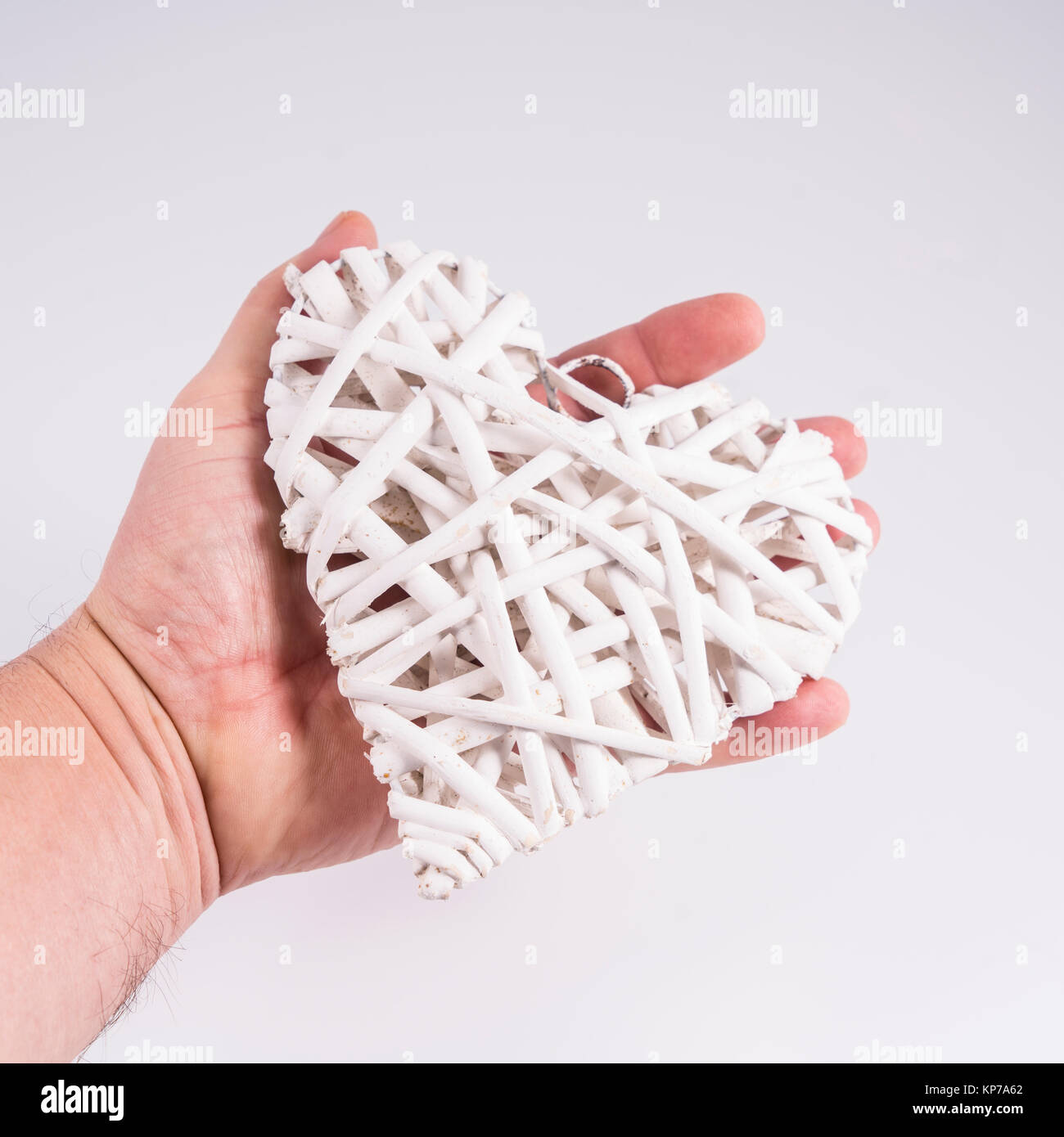 a heart formed with white colored wooden sprigs in hand Stock Photo