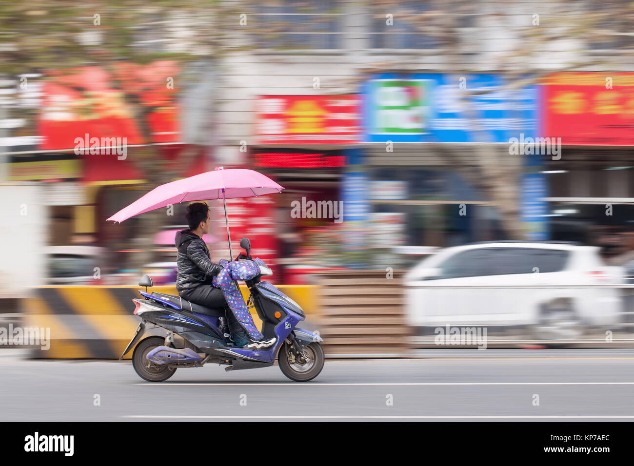 YIWU-CHINA-JAN. 15, 2016. Chinese man on an electric scooter. Thanks to government encouragement and a population well versed riding two wheels to wor Stock Photo