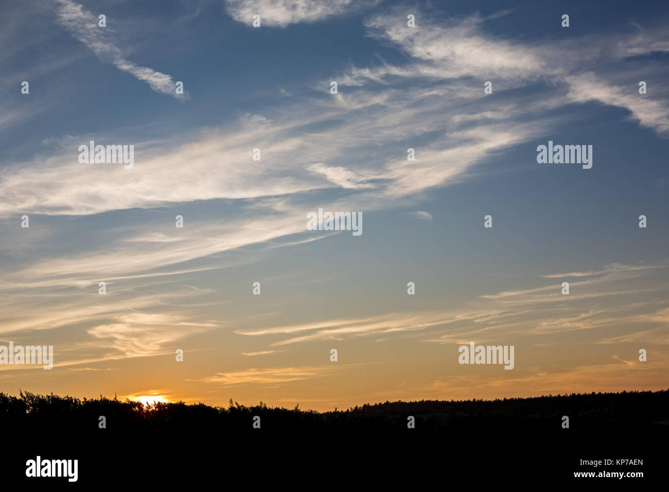 Horizontal cloudscape of layered clouds at sunset with Sun taken at ...