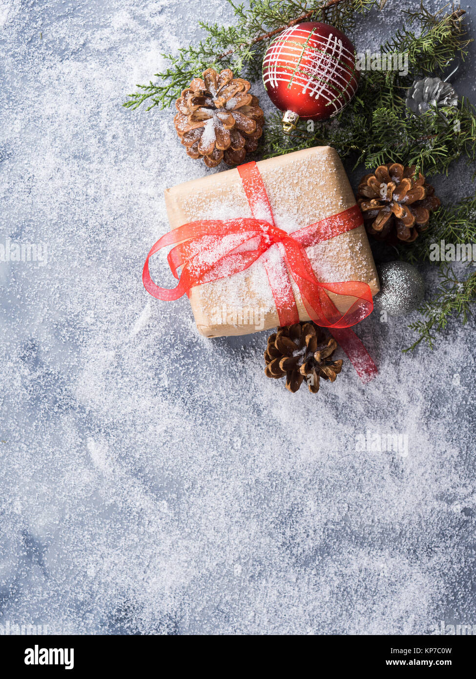 Christmas new year wrapped gift box with ribbon and snow. Pine cones ...