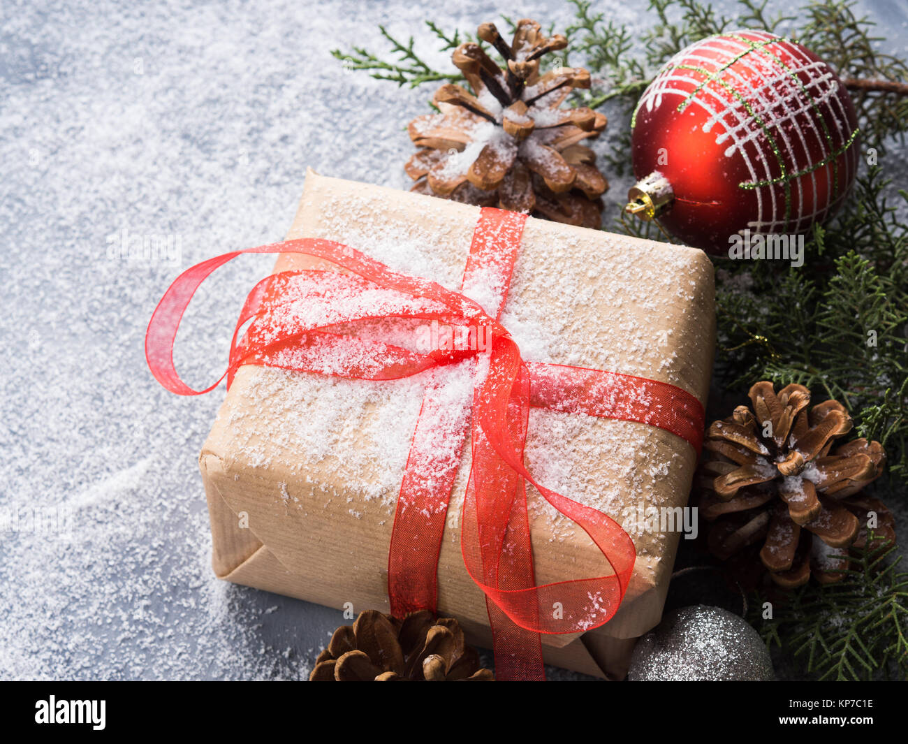 Christmas new year wrapped gift box with ribbon and snow. Pine cones ...