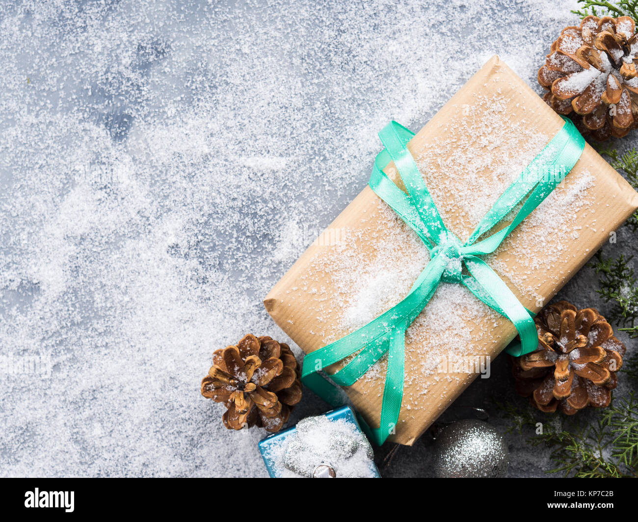 Christmas new year wrapped gift box with ribbon and snow. Pine cones ...